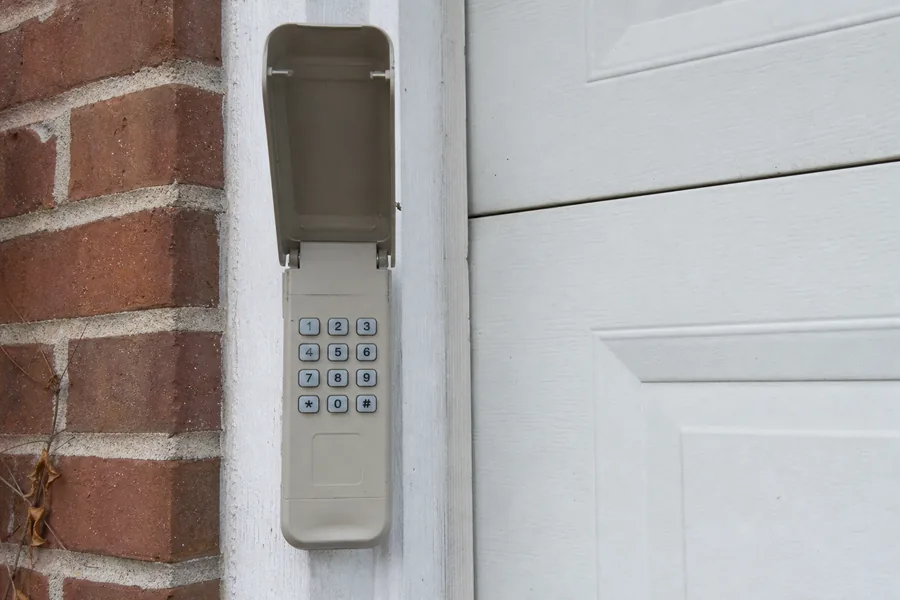 Keypad beside a garage door with snow on the drive